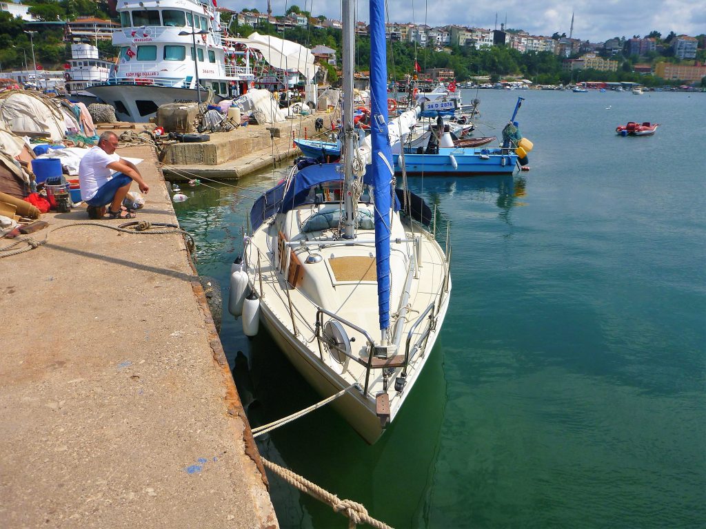 Яхта стоит у причальной стенкуи в порту.